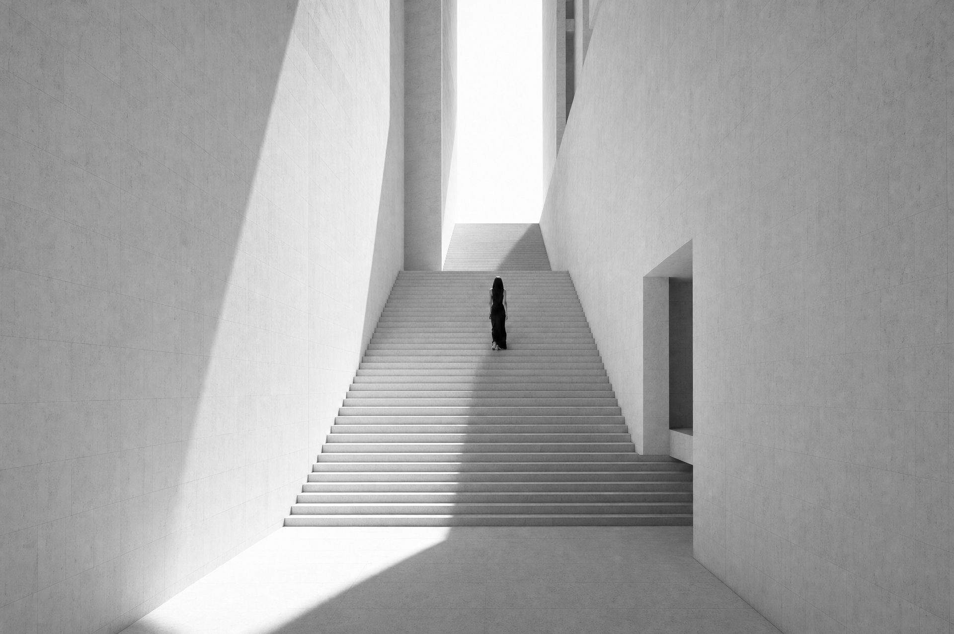 Eine Frau geht eine weiße Treppe hinauf ins Licht